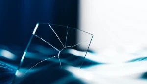 Imagen abstracta de la respuesta ante una brecha de seguridad, con un panel de vidrio fracturado que se recompone sobre un campo de luz azul